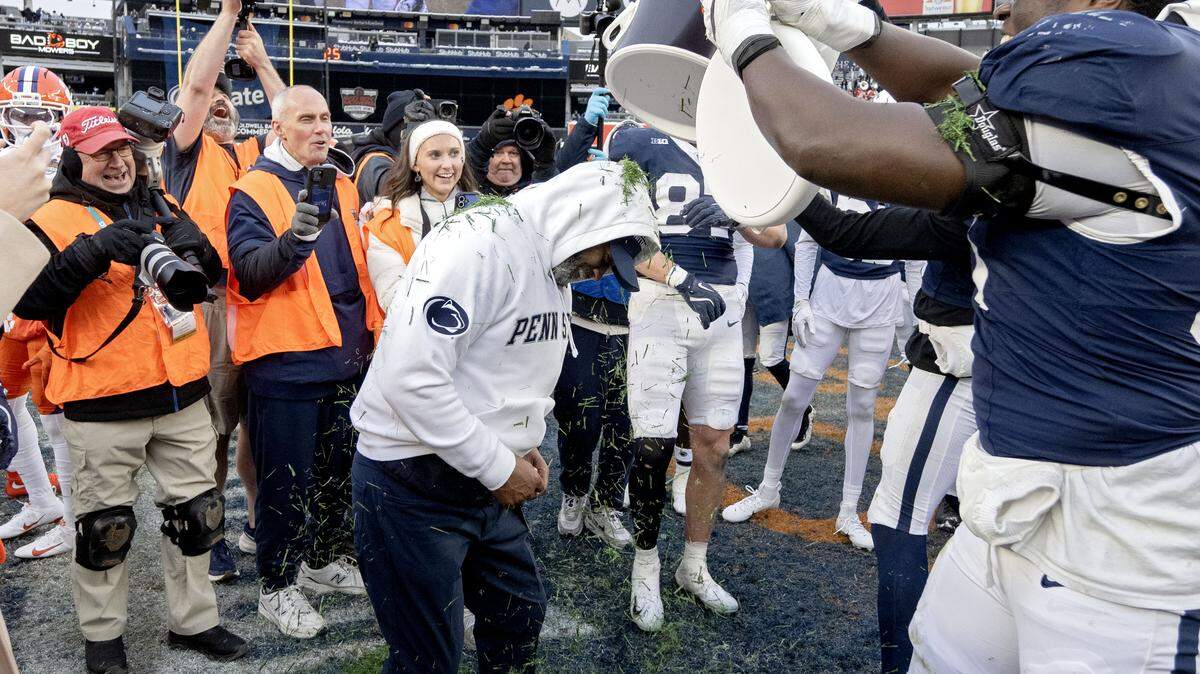 Penn State interim coach Terry Smith gets a cooler of grass dumped on him by cornerback Zion Tracy and offensive lineman Anthony Donkoh after the win over Clemson in the Pinstripe Bowl at Yankee Stadium on Saturday, Dec. 27, 2025.