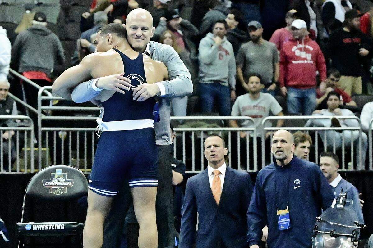 Penn State’s Aaron Brooks embraces coach Cael Sanderson on Saturday night at the T-Mobile Center in Kansas City, Mo. Brooks defeated N.C. State’s Trent Hidlay 6-1 to become the second Penn State wrestler (after Carter Starocci) to ever win four national titles.
