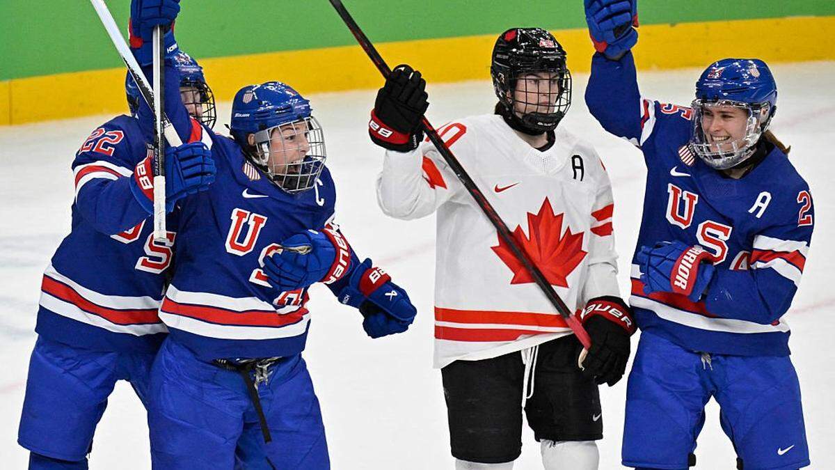 USA's #21 Hilary Knight (2L) celebrates scoring her team's first goal with USA's #25 Alex Carpenter (R) and USA's #22 Tessa Janecke (L) next to Canada's #40 Blayre Turnbull (2R) during the women's gold medal ice hockey match between USA and Canada at the Milano Santagiulia Ice Hockey Arena during the Milano Cortina 2026 Winter Olympic Games in Milan, on February 19, 2026. (Photo by Alexander NEMENOV / AFP via Getty Images)