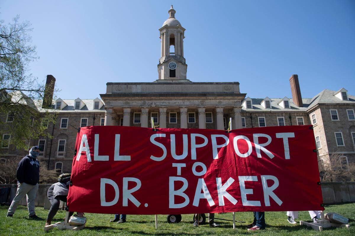Organizers set up a banner during a rally to protest the apparent mishandling of the process to dismiss Professor Oliver Baker in University Park, Pa., Thursday, April. 28, 2022.