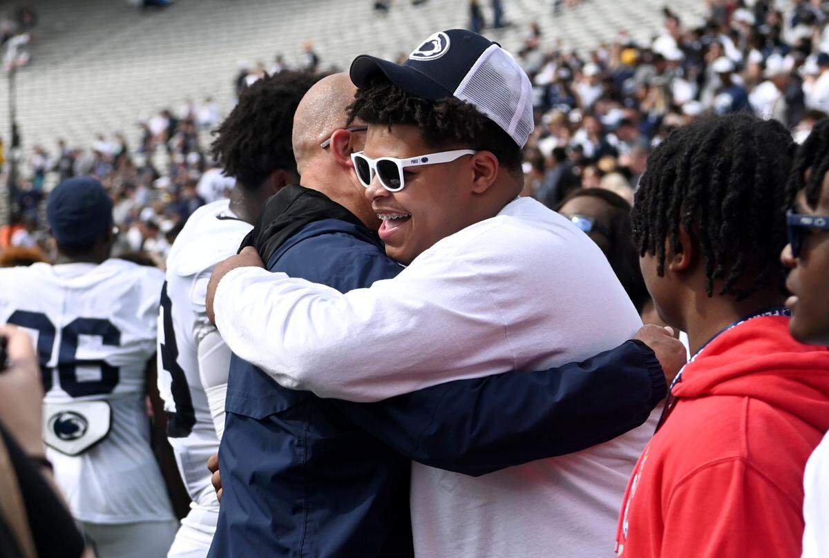 Penn State football coach James Franklin hugs Donovan Harbour after the Blue-White game on Saturday, April 15, 2023.