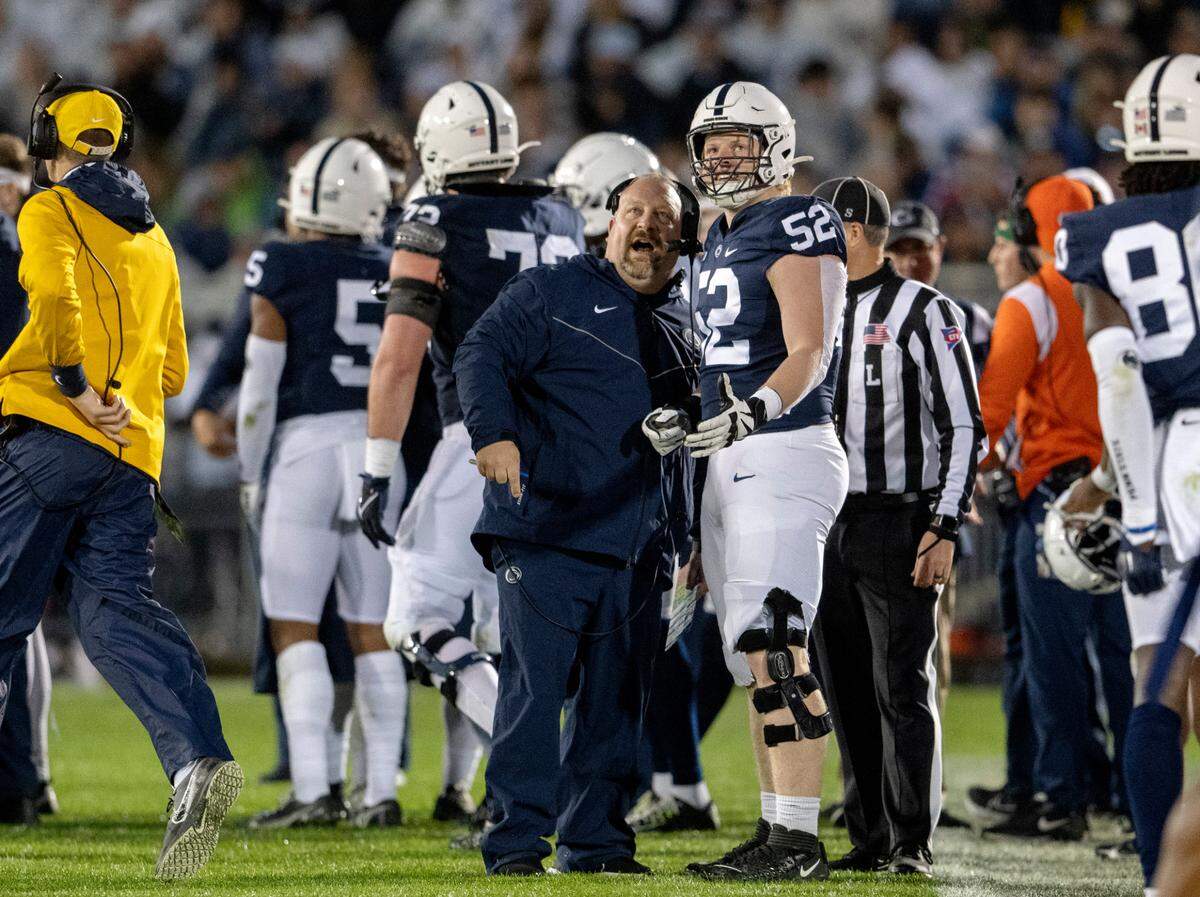 Penn State special teams coordinator Stacy Collins and defensive tackle Jordan van den Berg watch a replay during the game on Saturday, Nov. 12, 2022.