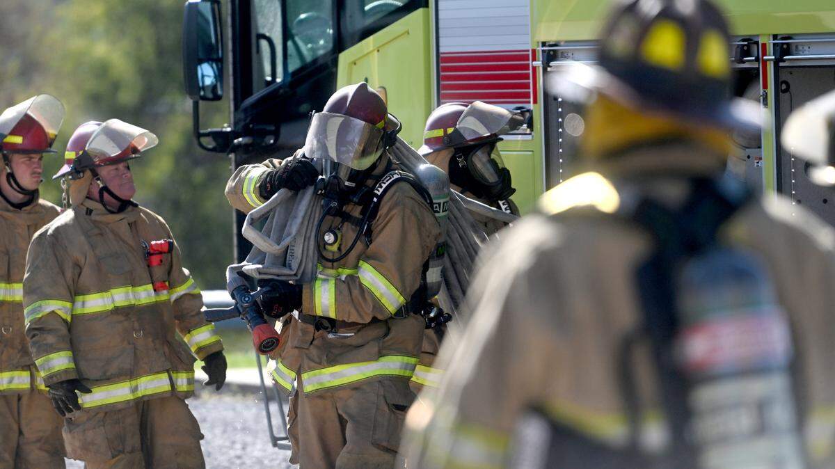 Firefighters from the University Park Airport pull hoses from the truck as they complete a building fire training session at the Centre County Public Safety Training Center on Wednesday, Oct. 11, 2023. 