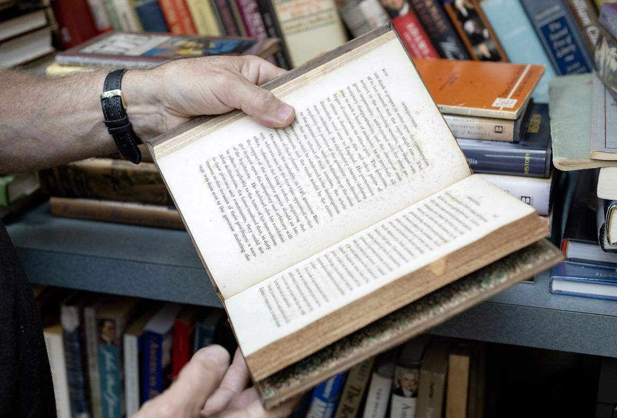 Keith Bierly of Forefathers Book Shop flips through a book that is part of a collection about the signers of the Declaration of Independence on Thursday Sept. 4, 2025.  