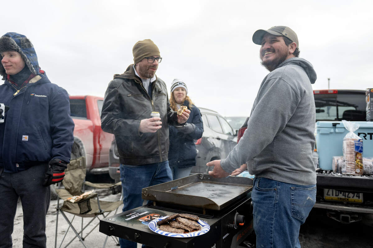 Jeff Childess warms his hands over the grill after making burgers at his tailgate outside of Beaver Stadium before the men’s hockey game on Saturday, Jan. 31, 2026.