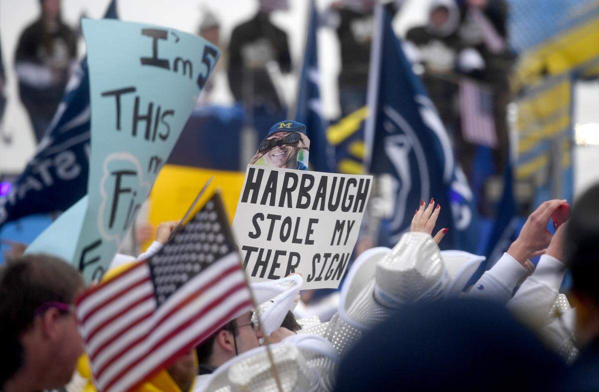 Penn State fans hold up signs at the Big Noon Kickoff about Jim Harbaugh before the game on Saturday, Nov. 11, 2023.