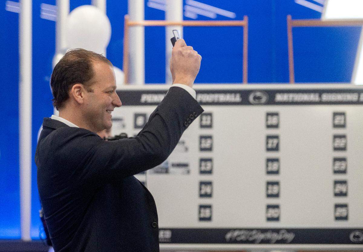 Penn State offensive coordinator Mike Yurcich holds up the name card for signee Jaxon Smolik during the National Signing Day celebration at the Lasch Building on Wednesday, Dec. 21, 2022.