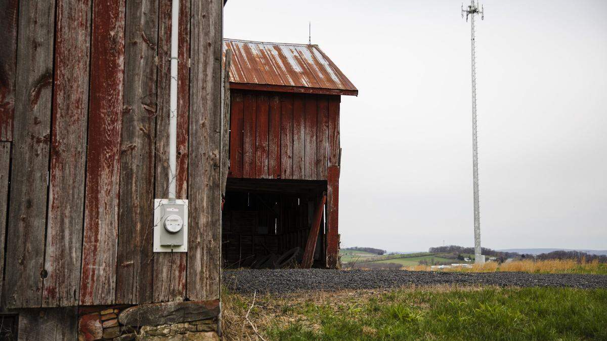 Red barn in rural Pennsylvania with a cellular tower in the background