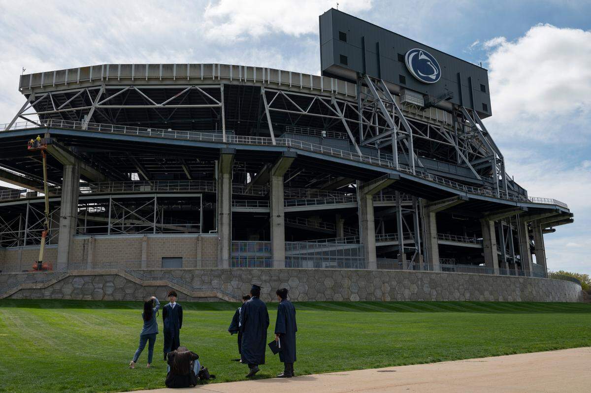 Penn State graduates take photos in front of Beaver Stadium on Thursday in University Park. Penn State will host in-person commencement ceremonies from Friday to Sunday.