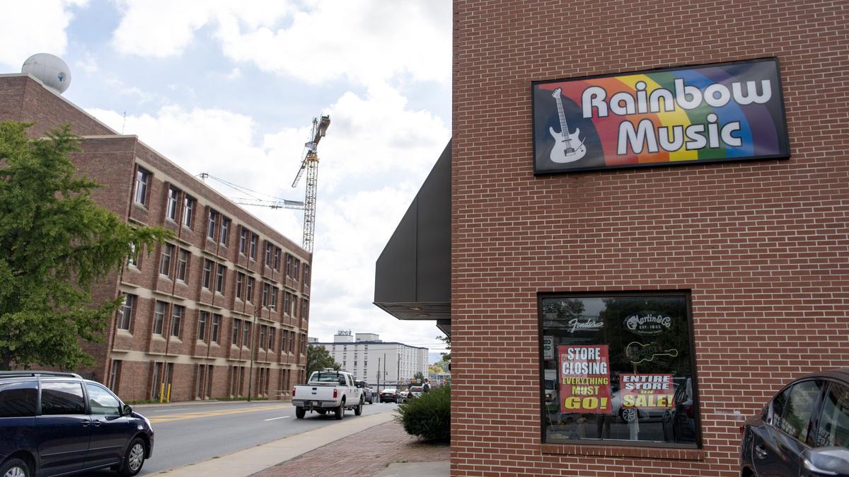 Store closing signs hang in the window of Rainbow Music on North Atherton Street.
