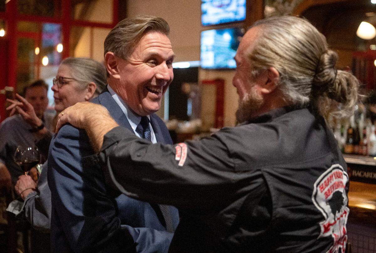 Paul Takac laughs with friends as they watch the polling numbers come in on Tuesday, Nov. 8, 2022.