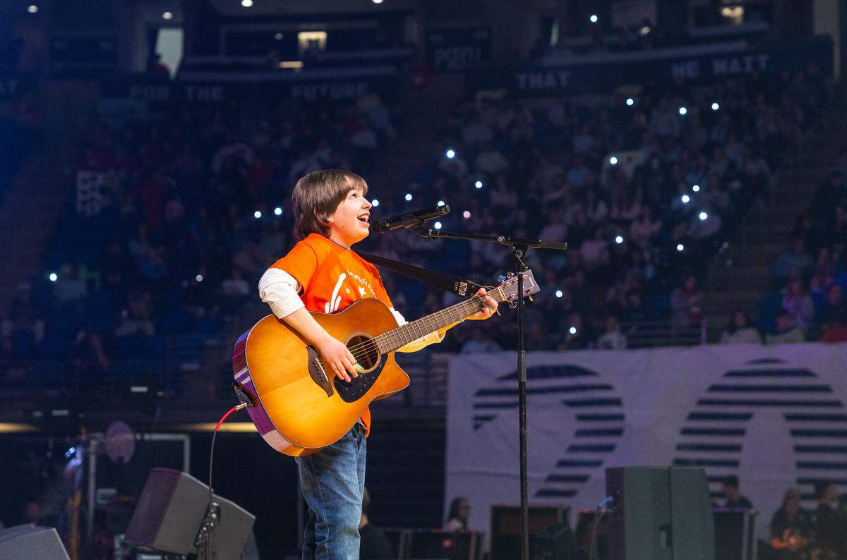 Easton Lee, brother of former Four Diamonds child and 2026 volunteer Braden Fleagle, sings a series of songs on stage during Thon on Friday, Feb. 20, 2026 in University Park, Pa.