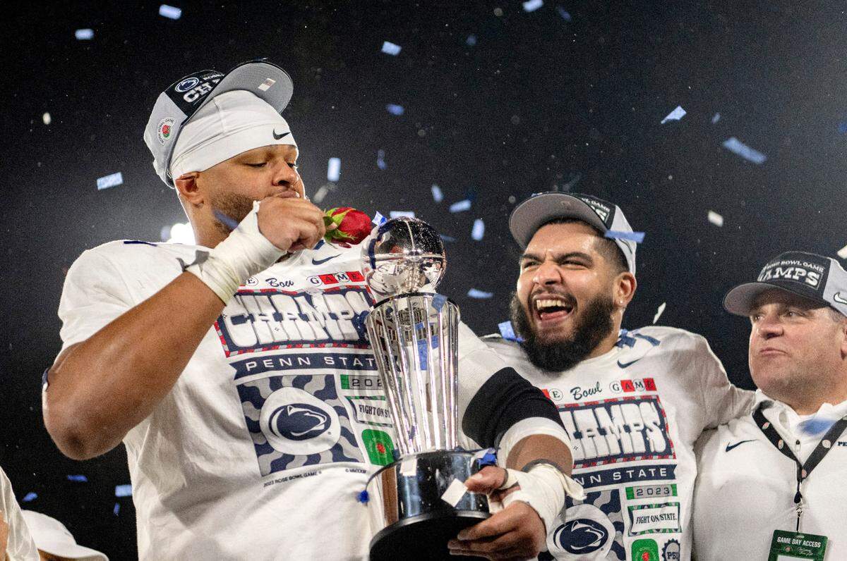 Penn State defensive tackle PJ Mustipher holds the Leishman Trophy as he and the team celebrate their Rose Bowl win over Utah on Monday, Jan. 2, 2023.