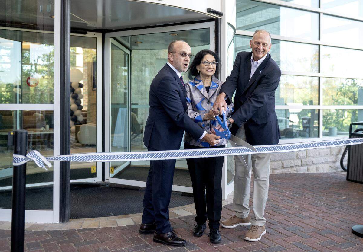 Scholar Hotel Group CEO Gary Brandeis, Penn State President Neeli Bendapudi and David Kleppinger, chair of the university’s board of trustees, cut a ribbon at the Penn Stater Hotel and Conference Center on Thursday, Oct. 9, 2025.