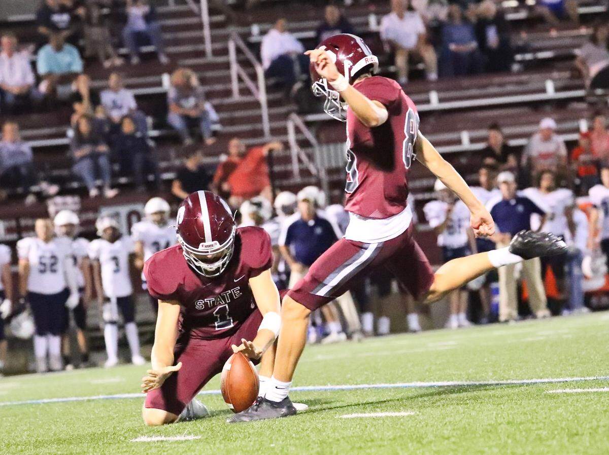State College’s Quinn Murphy goes to kick as Jack Morris holds against Chambersburg at Memorial Field on Sept. 17, 2021. State College won, 38-22.