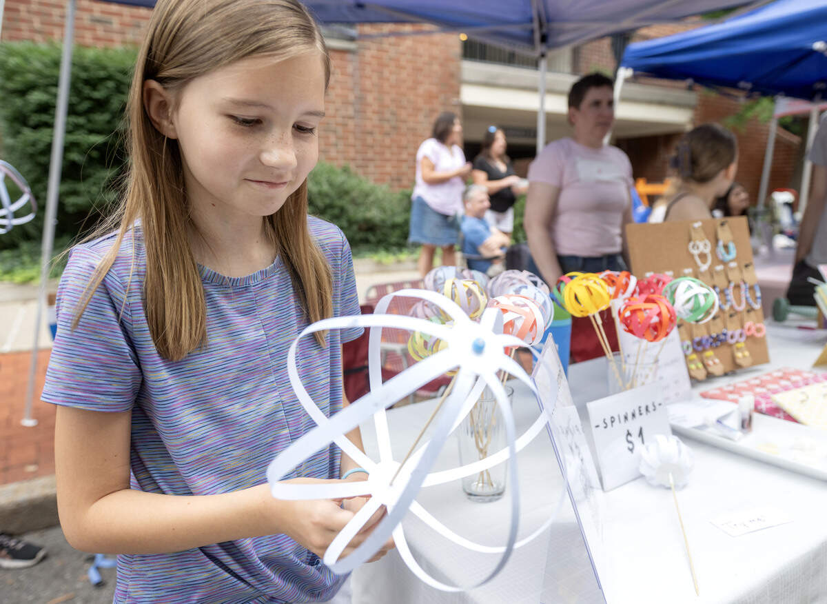 Elizabeth Moritz shows her paper spinners during the Children and Youth Day sidewalk sale at the Central Pennsylvania Festival of the Arts on Wednesday, July 8, 2026.