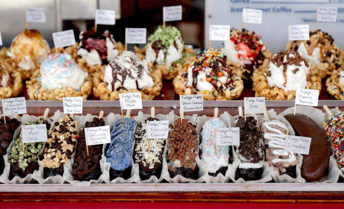An assortment of fudge puppies, which are a Belgian waffle on a stick, coated in chocolate and finished with toppings, at Ruble’s Concessions at Centre County Grange Fair on Friday, Aug. 16, 2024.