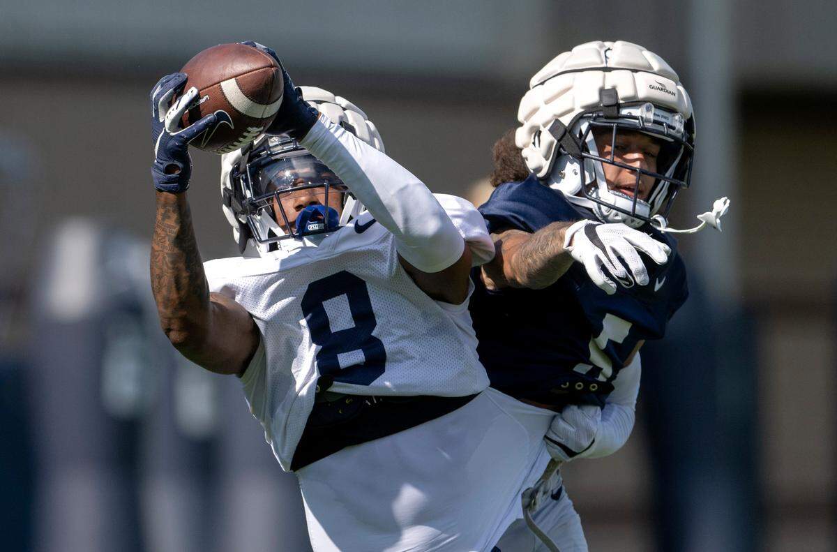Penn State wide receiver Tyler Johnson makes a catch ahead of cornerback Cam Miller during practice on Saturday, Aug. 20, 2022.