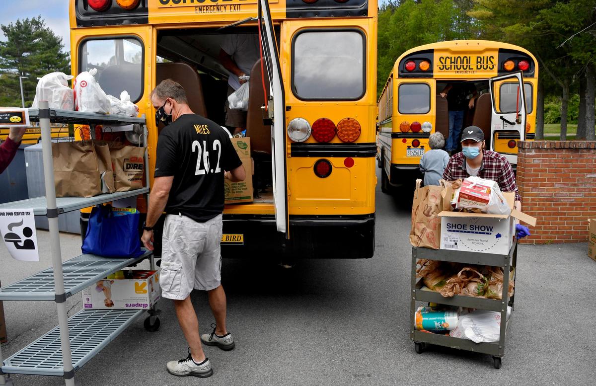 State College Area school district employees unload the thousands of donated items for the food bank from school buses on Thursday, May 21, 2020.