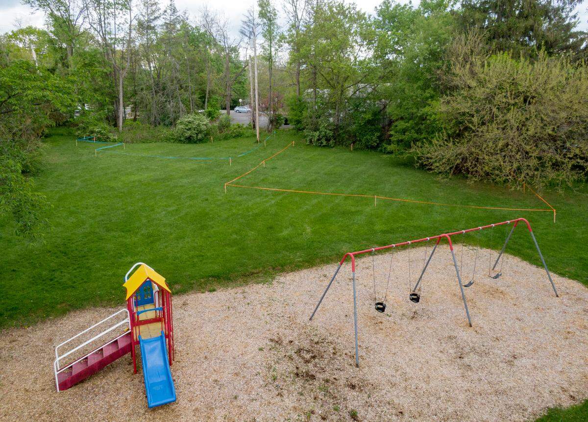 Nittany Village Park has stakes and tape outlining the footprint of a proposed building and parking lot that a developer estimates would take 16% of the park.