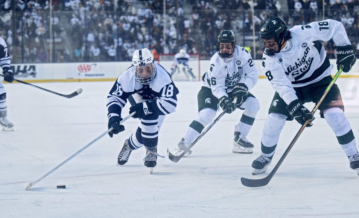 Penn State's Aiden Fink skates around Michigan State’s Ryker Lee during overtime of the game on Saturday, Jan. 31, 2026 at Beaver Stadium.