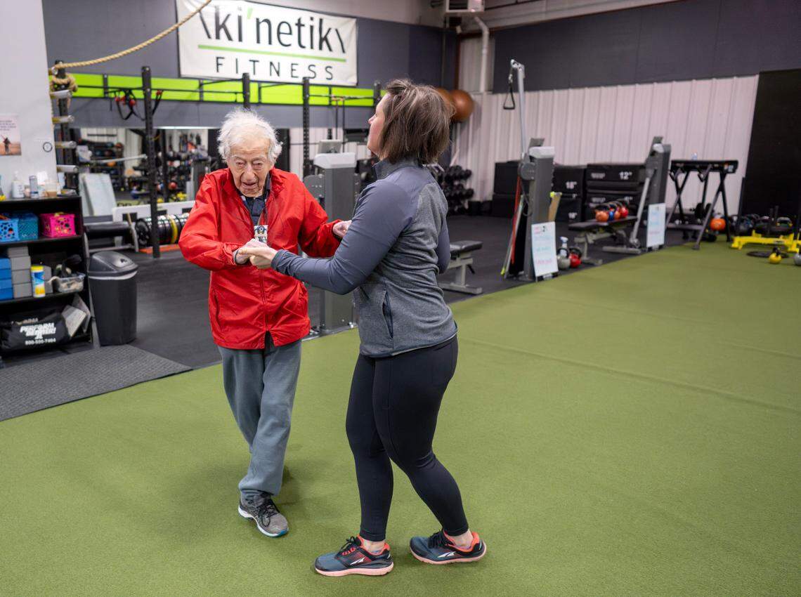 George Etzweiler “dances” with Berta DeDonato as he warms up for his work out at Ki’netik Fitness on Friday, April 5, 2024.