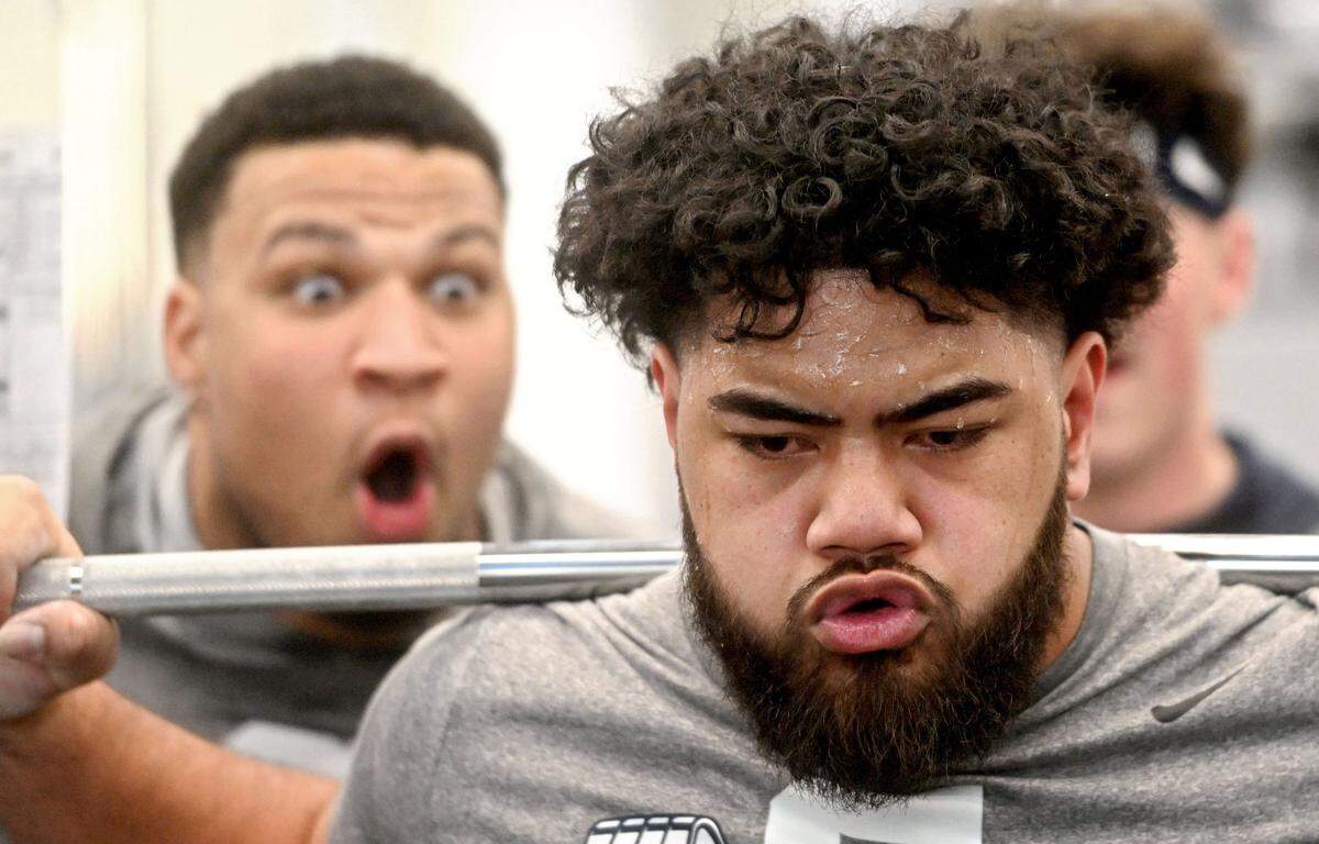 Penn State offensive lineman Vega Ioane is cheered on by teammate Nick Dawkins as he lifts during a winter workout on Thursday, Feb. 29, 2024.