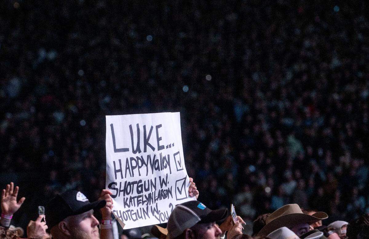 Fans hold up a signs and sign along to Luke Combs during his performance at Beaver Stadium on Saturday, April 27, 2024.