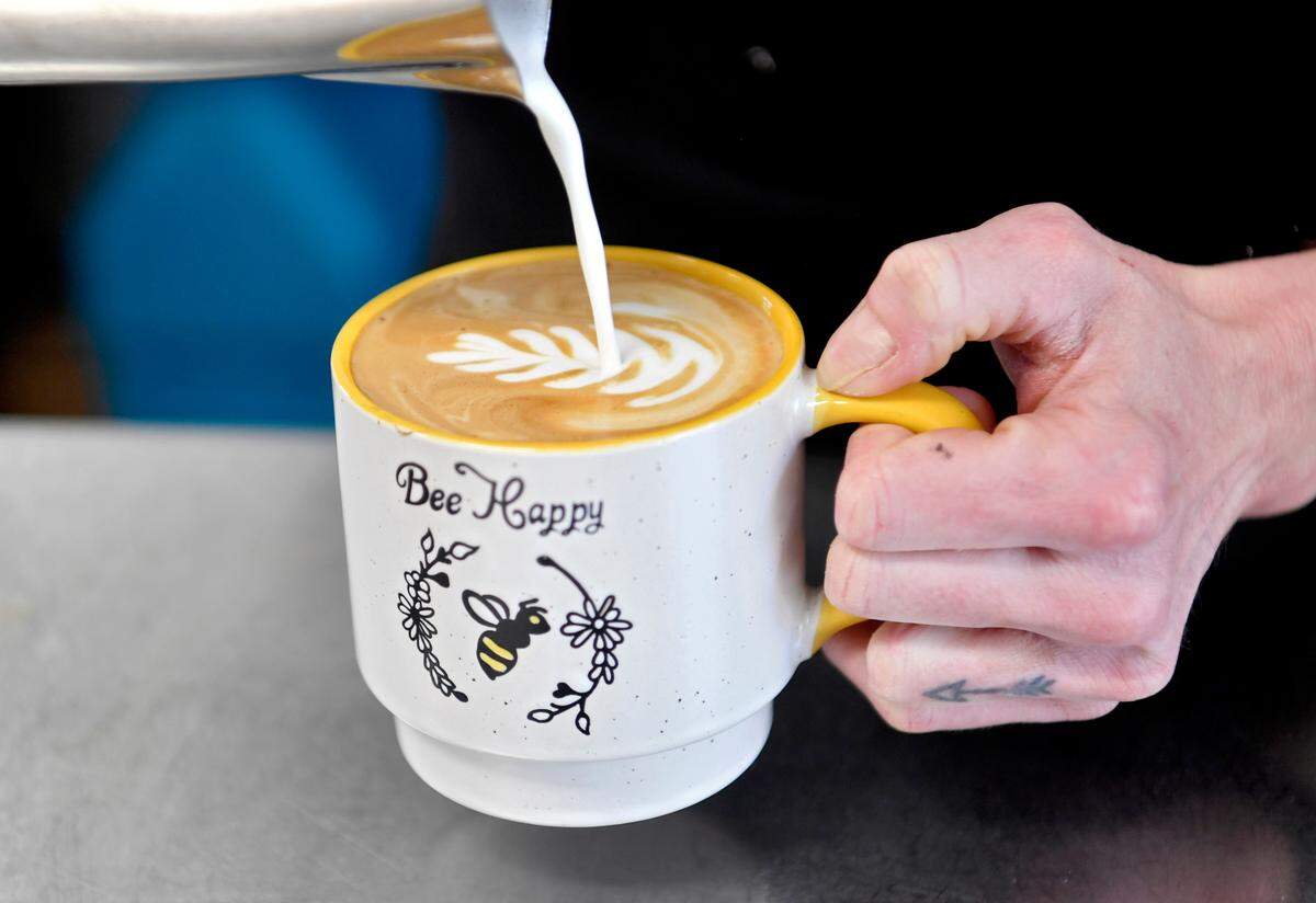 Bromlyn Fitzgerald of Bees Knees Coffee makes a design in a latte on Wednesday.
