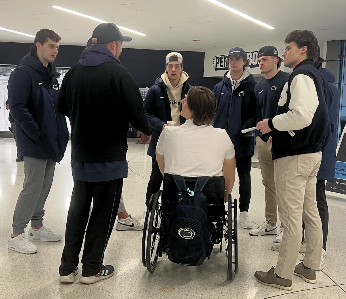 Members of the Penn State men’s hockey team huddle around Max Malec moments before his signing ceremony the morning of the third annual Sled Hockey Classic