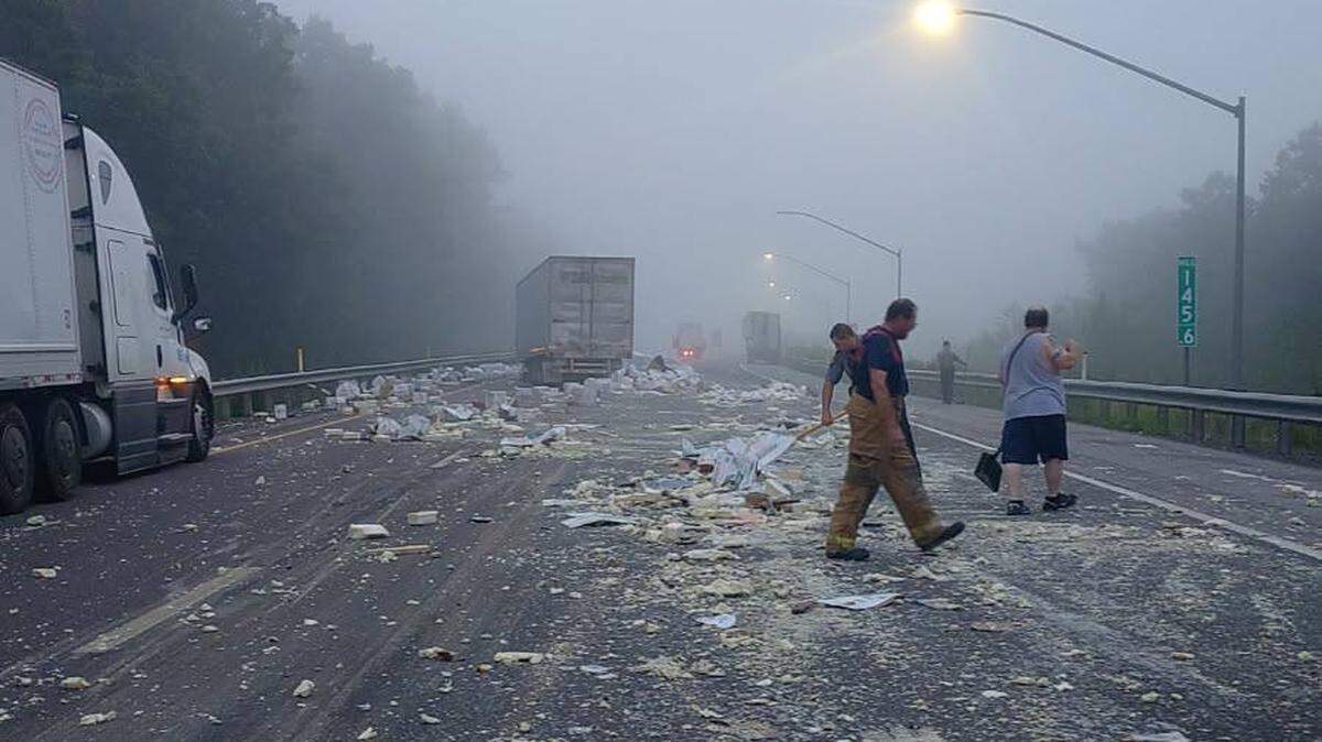 Crews work on cleaning up debris on I-80 after a collision caused hundreds of boxes of mozzarella cheese to spill onto the road.