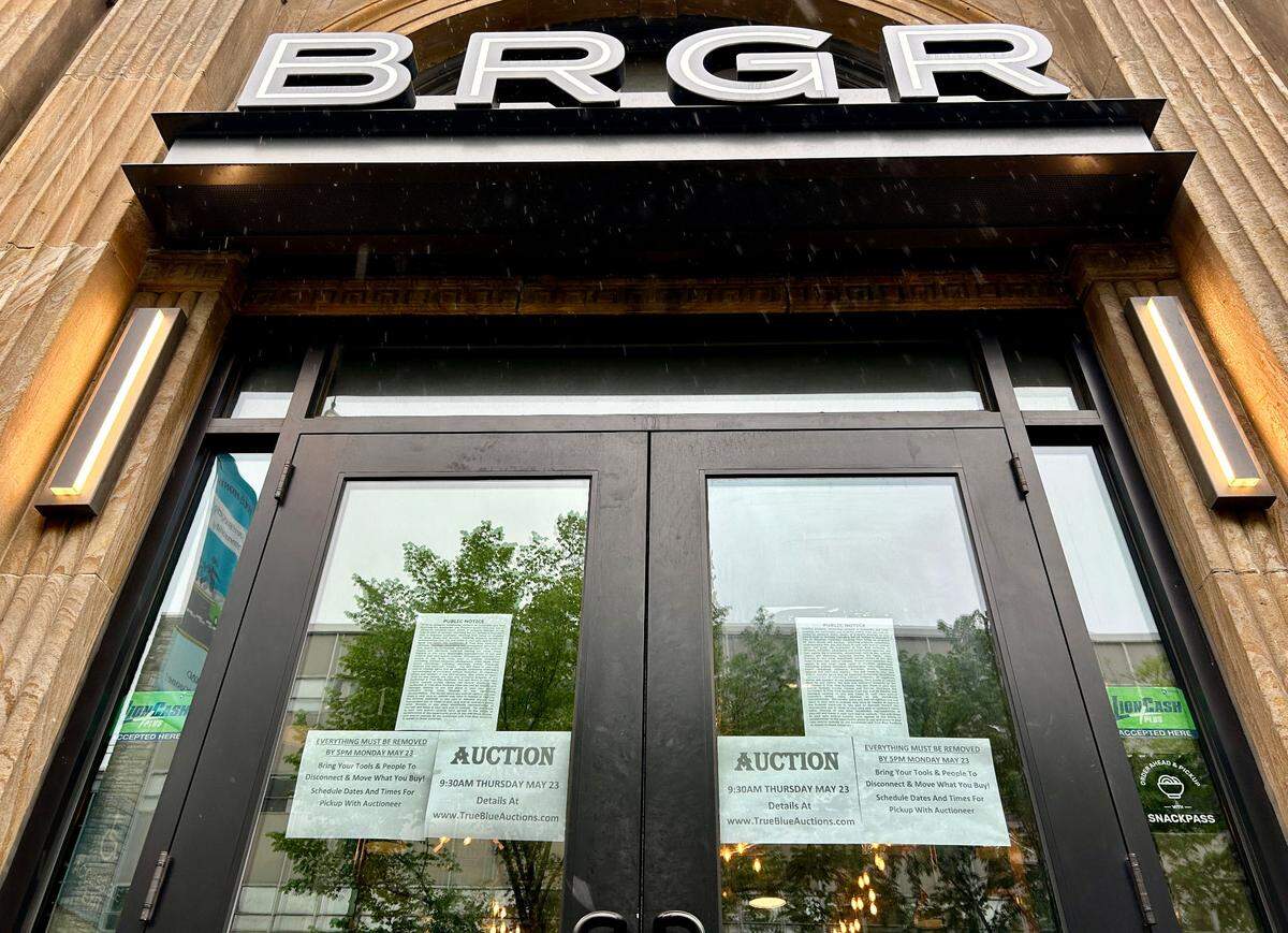 Signs about an upcoming auction on the doors to BRGR on College Avenue in downtown State College on Friday, May 10, 2024.