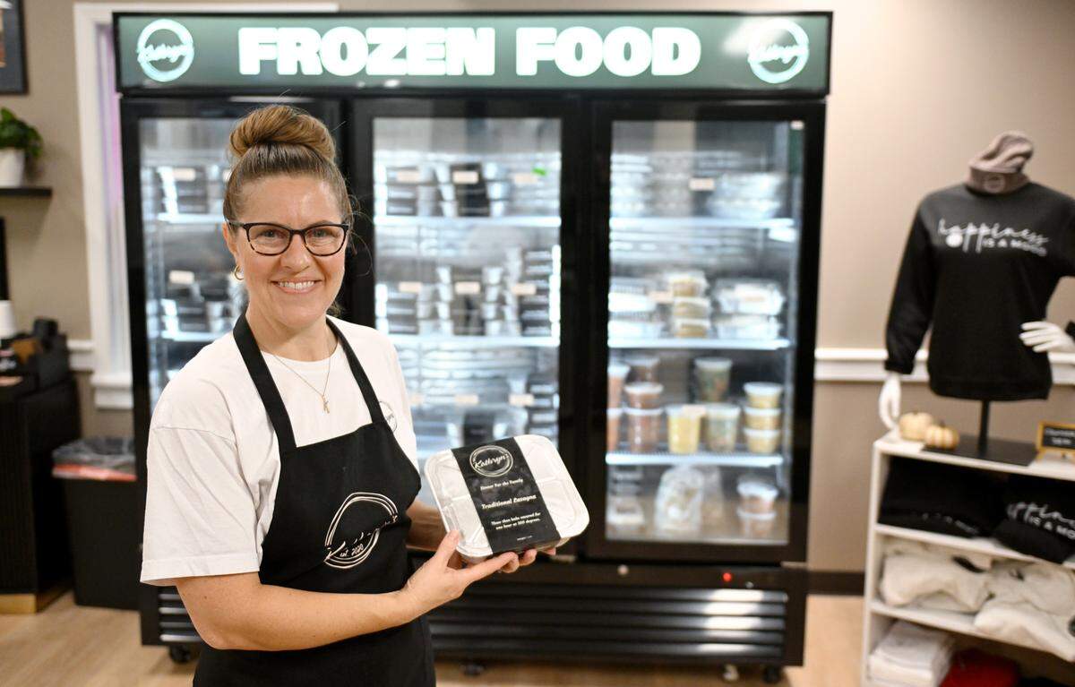 Kathryn Fisher of Kathryn’s holds a tray of lasagna, which is one of the many frozen meals she offers in her shop.