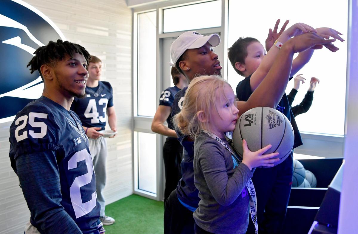 Addilyn Brommer, 3, get ready to make a shot as she plays with Penn State freshman Daequan Hardy in the Lasch Building on Saturday, Feb. 22, 2020.