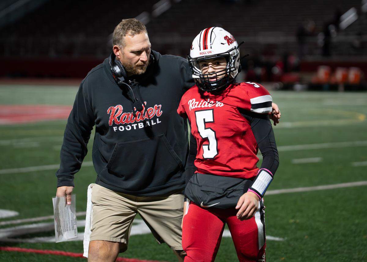 Bellefonte freshman quarterback Alten Howell (5) talks with his coach during a Friday night football game against Greater Johnstown in Bellefonte, Pa., on Oct. 24, 2025. The Red Raiders beat the Trojans 31-19.