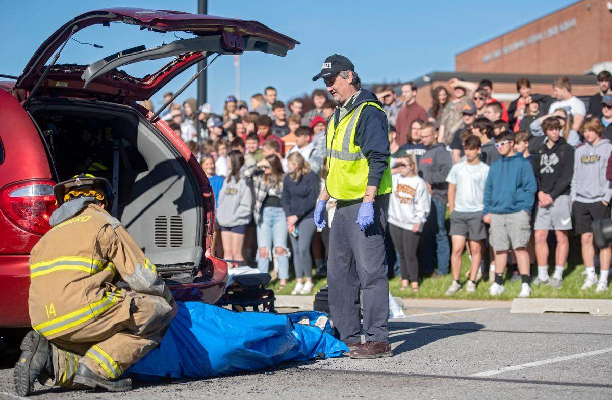 Bald Eagle Area High School students watch as Centre County coroner Scott Sayers, firefighters and EMTs work at the scene of a mock car accident on Tuesday, May 10, 2022.