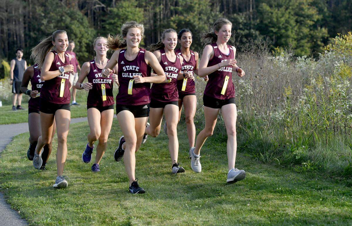 The front pack of State College girls cross country runners laugh as they come around a turn during the race against Hollidaysburg on Tuesday, Oct. 1, 2019 at Circleville Park.