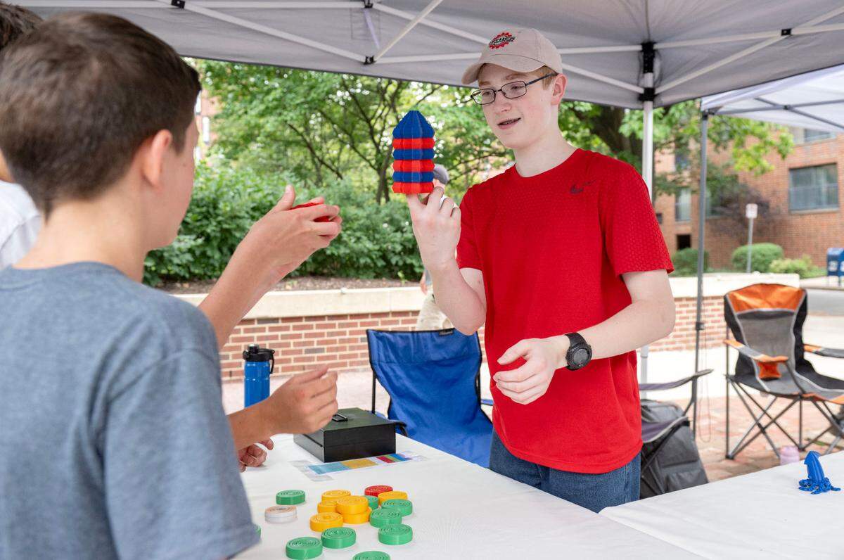 Micah Hall, 14, stacks some of his 3-D printed fidget spinners during the Central Pennsylvania Festival of the Arts Children and Youth sidewalk sale on Wednesday, July 9, 2025.