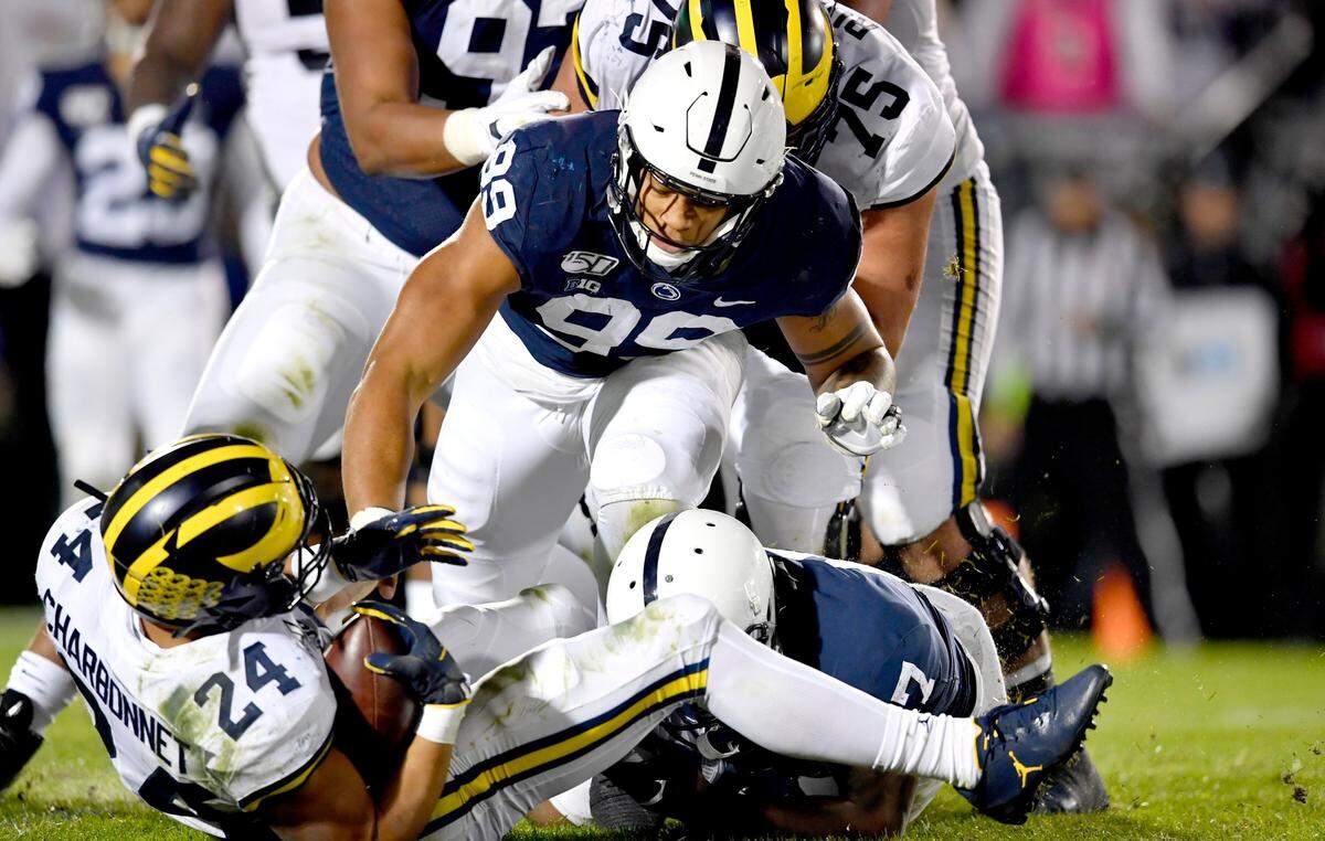 Michigan running back Zach Charbonnet is taken down by Penn State defensive end Yetur Gross-Matos and safety Garrett Taylor during the game on Saturday, Oct. 19, 2019.