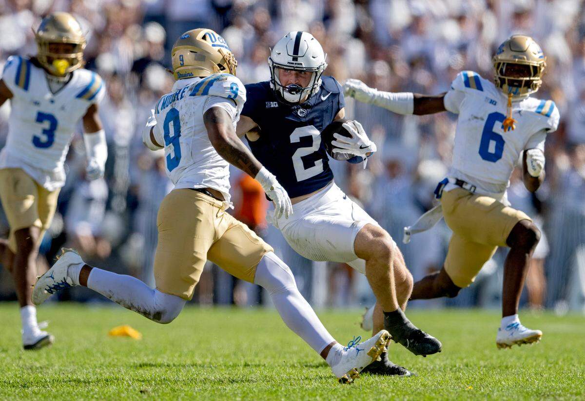 Penn State wide receiver Liam Clifford cuts down the field with the ball from UCLA’s Kaylin Moore during the game on Saturday, Oct. 5, 2024 at Beaver Stadium.