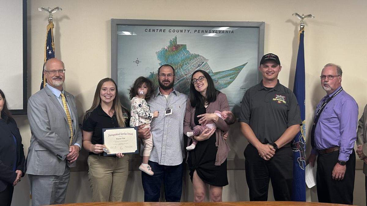 Commissioners Amber Concepcion and Mark Higgins, Centre County 911 dispatcher Keara Tice, Adeline, Braden, Lauren and Everly, Centre County 911 supervisor Trevor Harris, Centre County Emergency Communications Director Norm Spackman and Commissioner Steve Dershem lined up to commemorate Tice’s achievement.