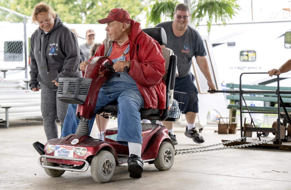 Norman Wenrich uses his feet to help his scooter go a little farther in the scooter pull at the Centre County Grange Fair on Thursday, Aug. 21, 2025.  