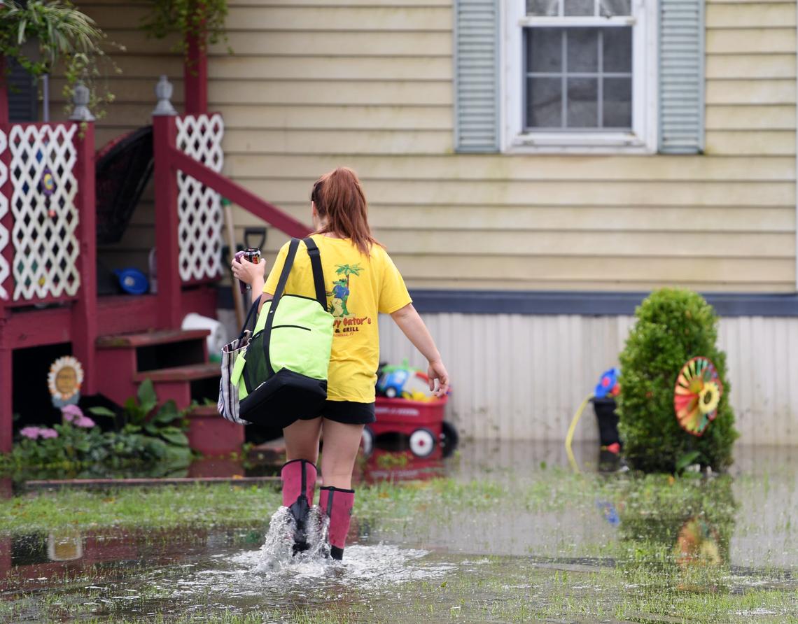 Morgan Reader walks through her flooded front yard in Curtin Park Court on Tuesday after Monday’s heavy rainfall in Osceola Mills.