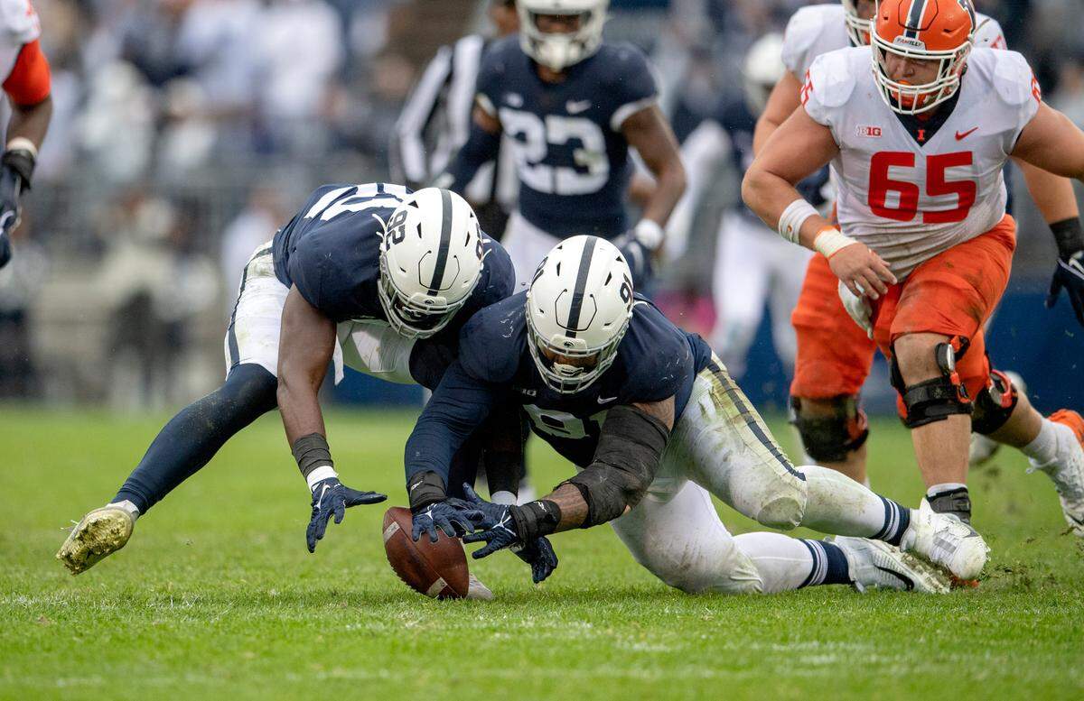 Penn State defensive end Smith Vilbert and defensive tackle Dvon Ellies dive to the ball after Illinois quarterback was sacked during the game against Illinois on Saturday, Oct. 23, 2021.