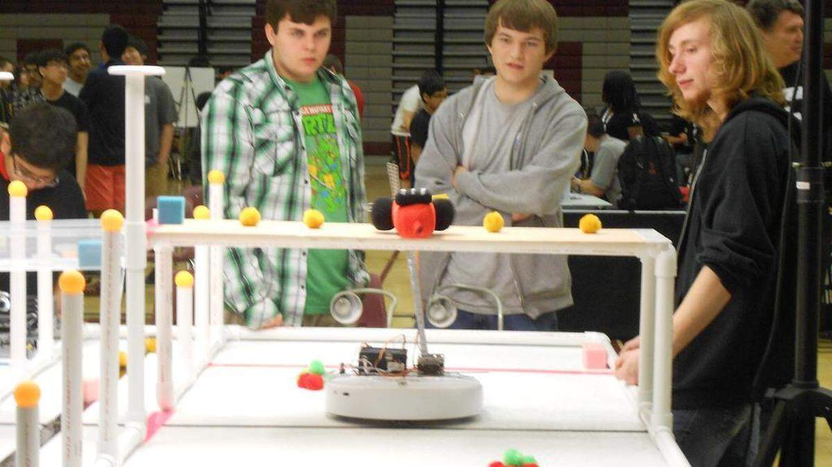 Seniors Nick Carlson, Nick Pytel and Anthony Daniels set up and prepare to compete at the Greater DC Botball tournament. 
