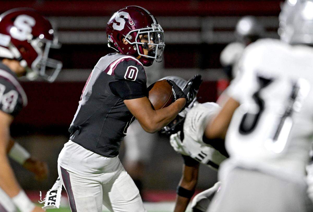 State College’s D’Antae Sheffey tries to cut around Harrisburg defenders during the game on Friday, Oct. 13, 2023.
