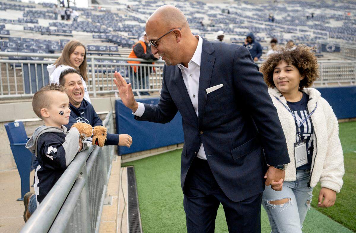 Penn State football coach James Franklin high fives Henrik Ebersole, 4, as he arrives at Beaver Stadium for the game on Saturday, Oct. 1, 2022.