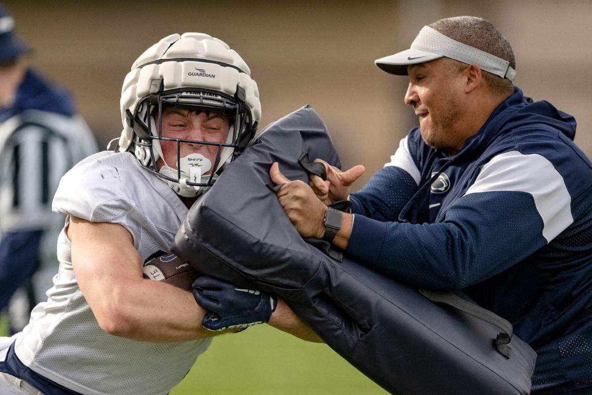 Penn State’s back Tyler Holzworth pushes past running backs coach Ja’Juan Seider during a drill at practice on Tuesday, April 11, 2023.