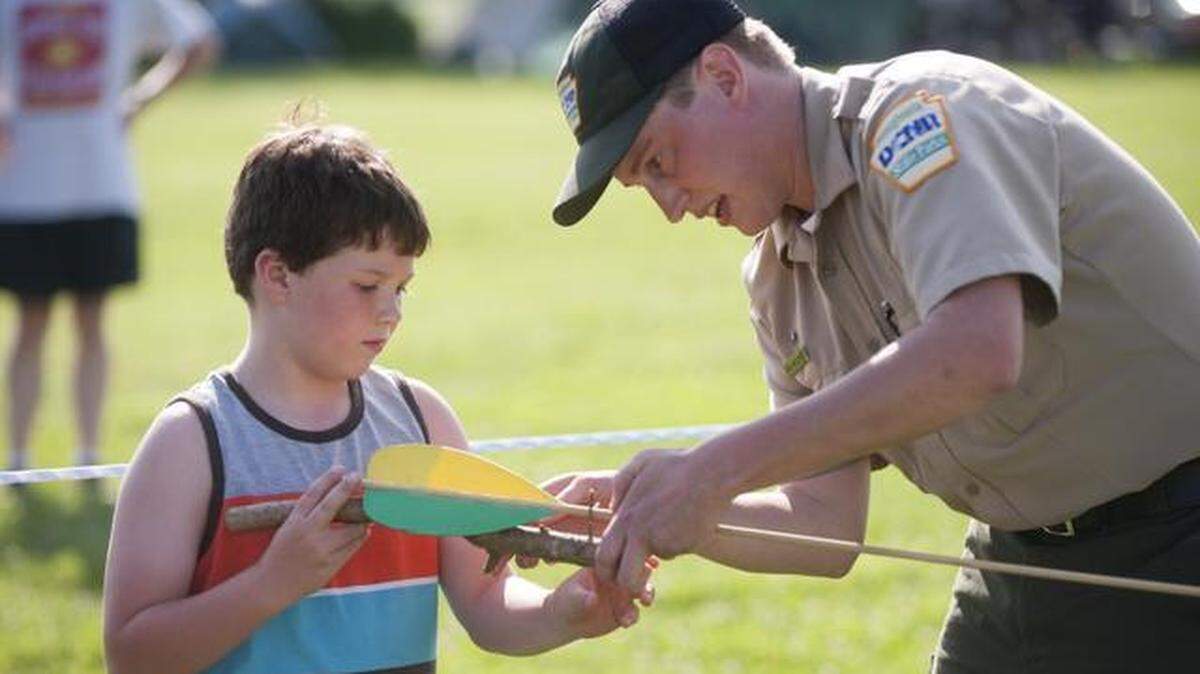 Christian Swartwood gets assistance from Zach McCloskey, an environmental education specialist at Bald Eagle State Park, while throwing a spear using an atlatl during a Knap-In at the park on Friday.
