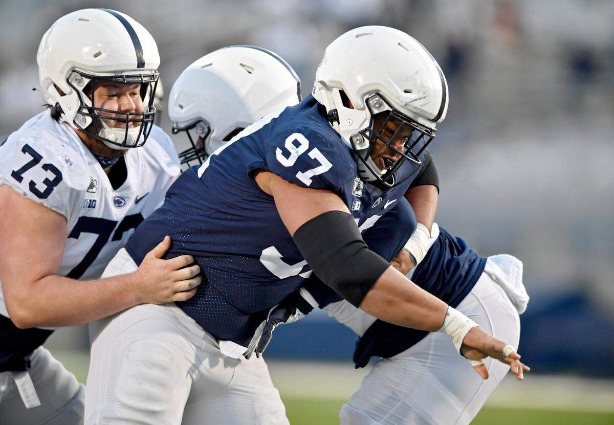 Defensive tackle PJ Mustipher pushes past offensive linemen during Penn State football practice on Friday, April 23, 2021 at Beaver Stadium.